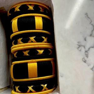Black bangles with gold design.